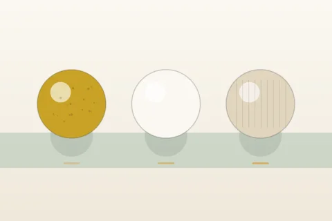 Trois balles de baby-foot, liège, plastique et résine texturée, alignées